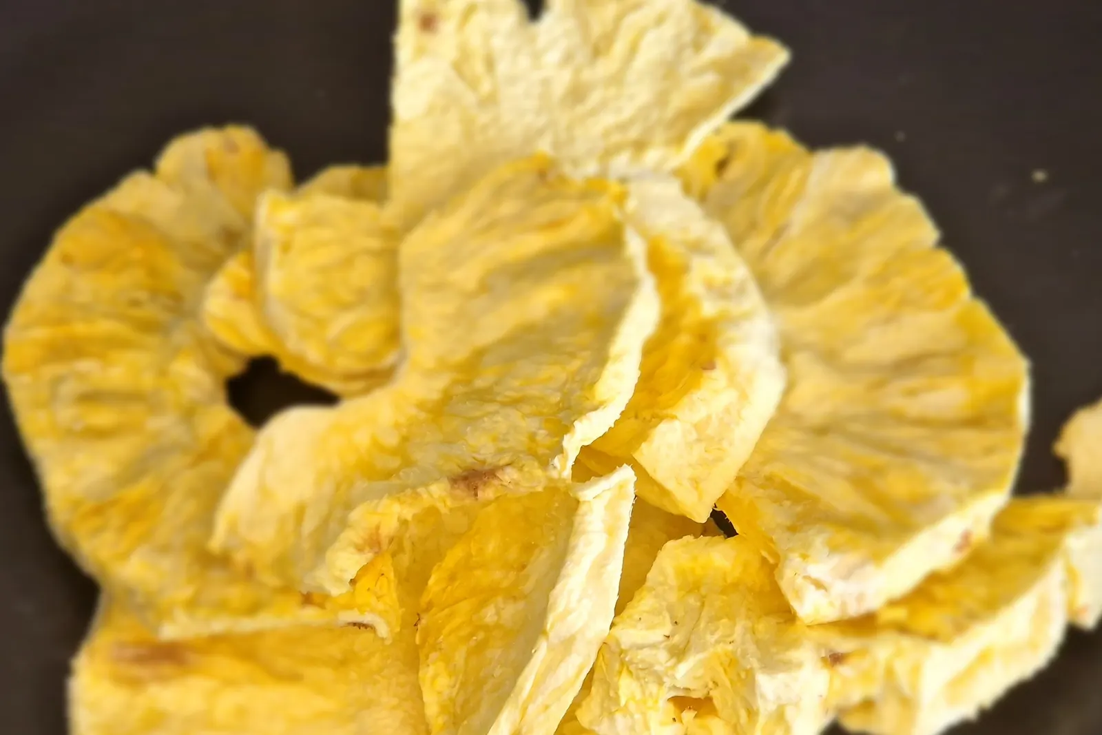Rodajas de piña liofilizada, pálidas y mates, que conservan entera su forma de anillo
