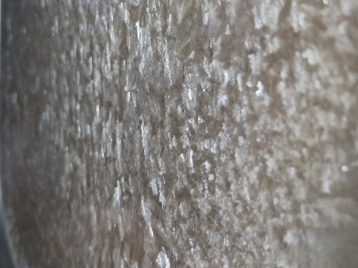 Primerísimo plano de la superficie del caldo de vacuno congelado a mitad de ciclo, con cristales de hielo y una matriz porosa a la vista